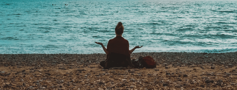 Femme faisant du yoga sur la plage